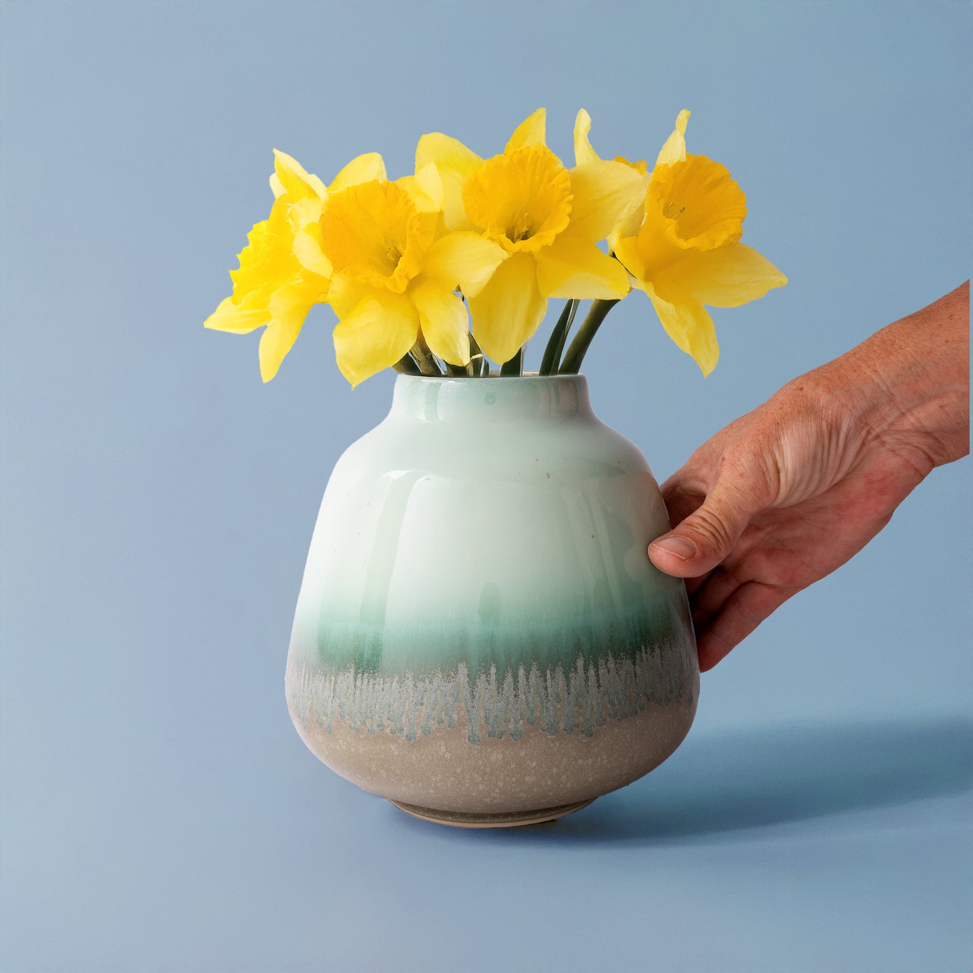 Pottery For The Planet bouquet vase for home decor with green and beige glaze holding yellow daffodils