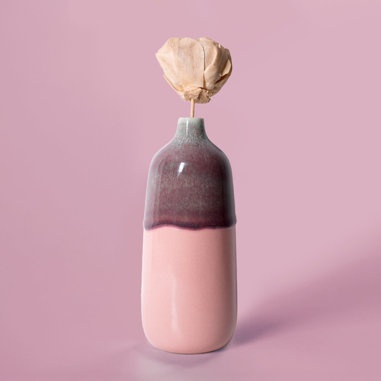Pottery For The Planet eco-friendly home decor vase with pink and purple glaze holding a dried flower