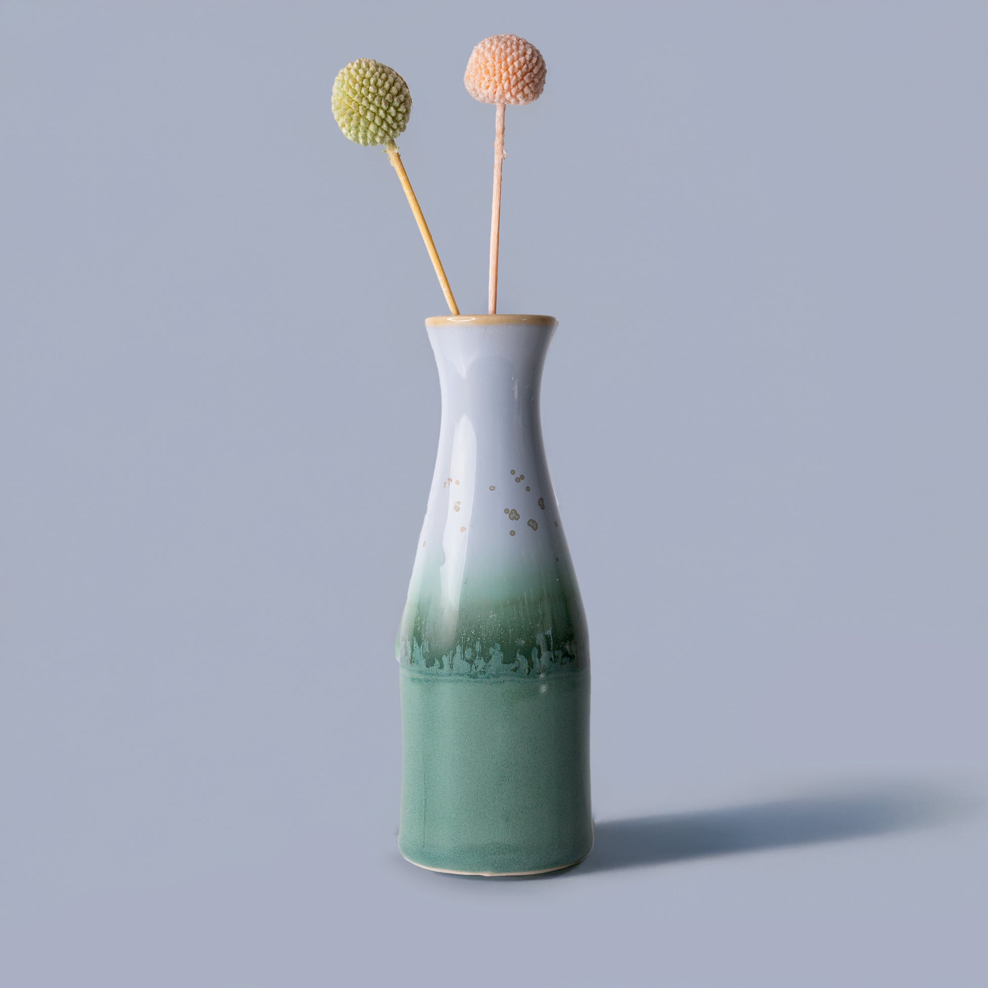 Pottery For The Planet unique ceramic flower vase with green and white glaze holding two decorative stems