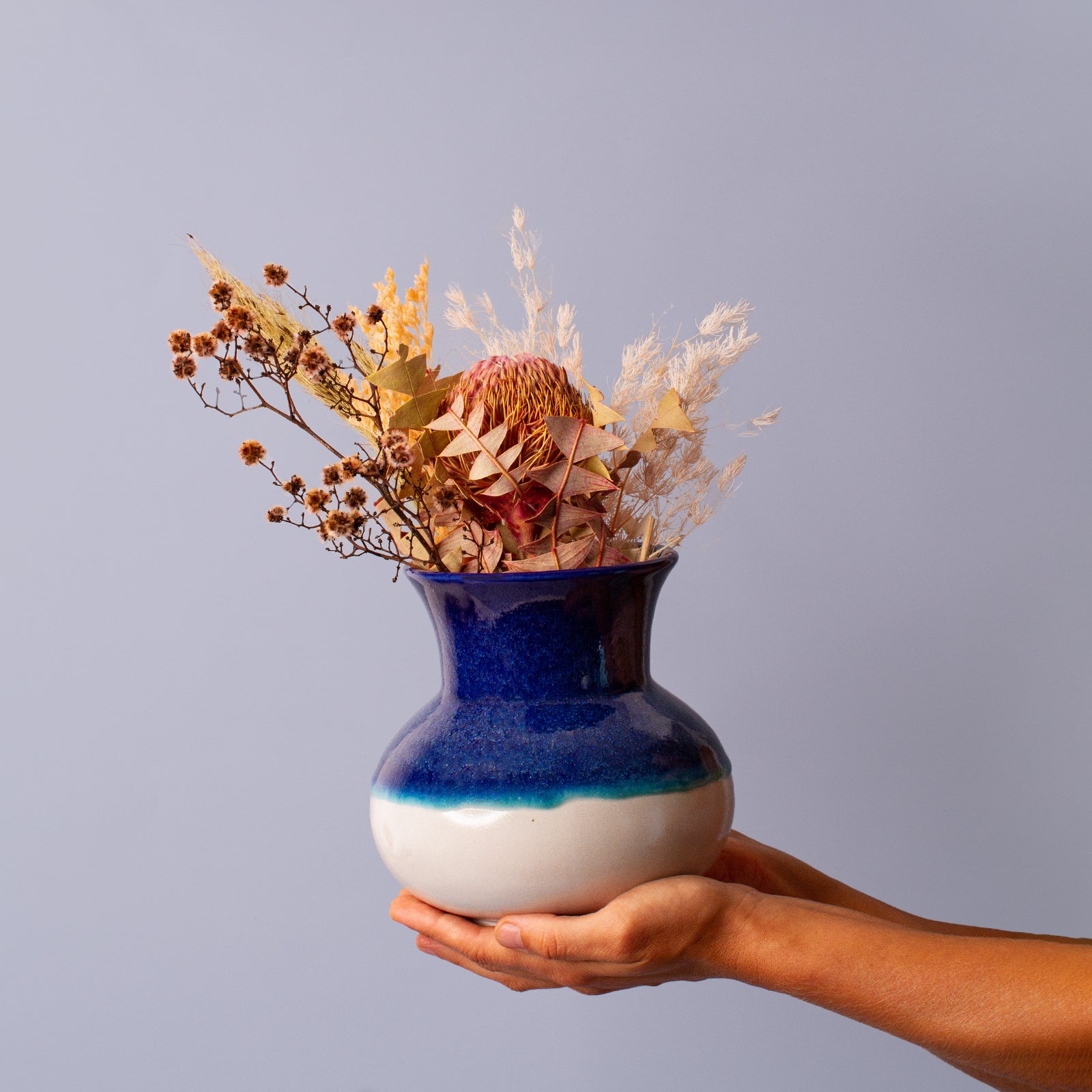 blue and white ceramic vase in hand