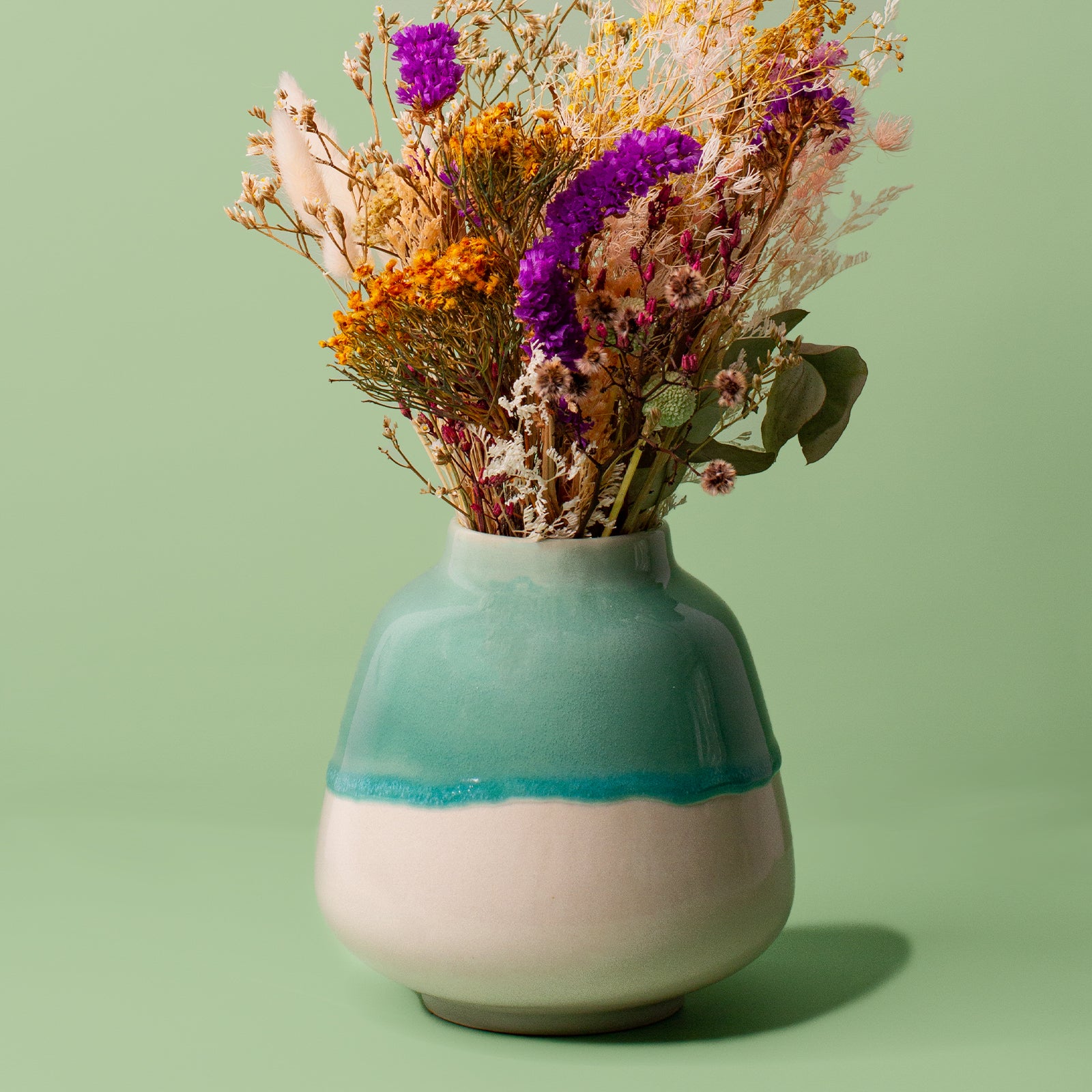 Pottery For The Planet ceramic bouquet vase for home decor with green and cream glaze holding dried flowers