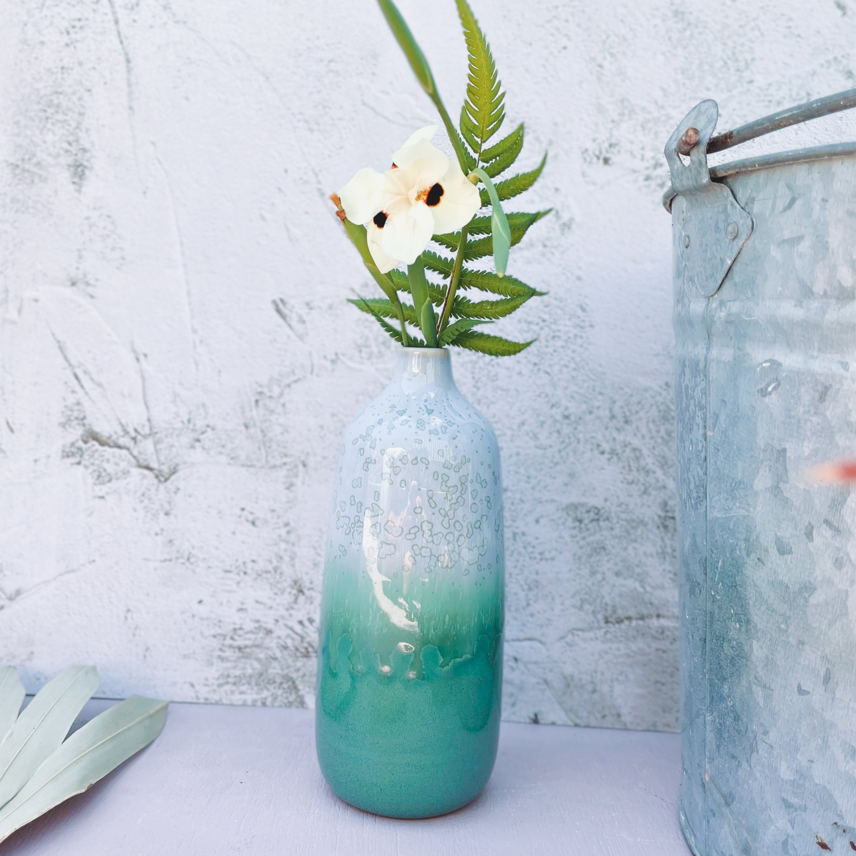 Pottery For The Planet eco-friendly home decor vase with green and white gradient holding flowers and fern leaves