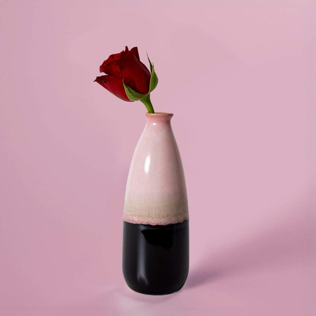 Pottery For The Planet pink and black artisan decorative vase for flowers with a single red rose on pink background