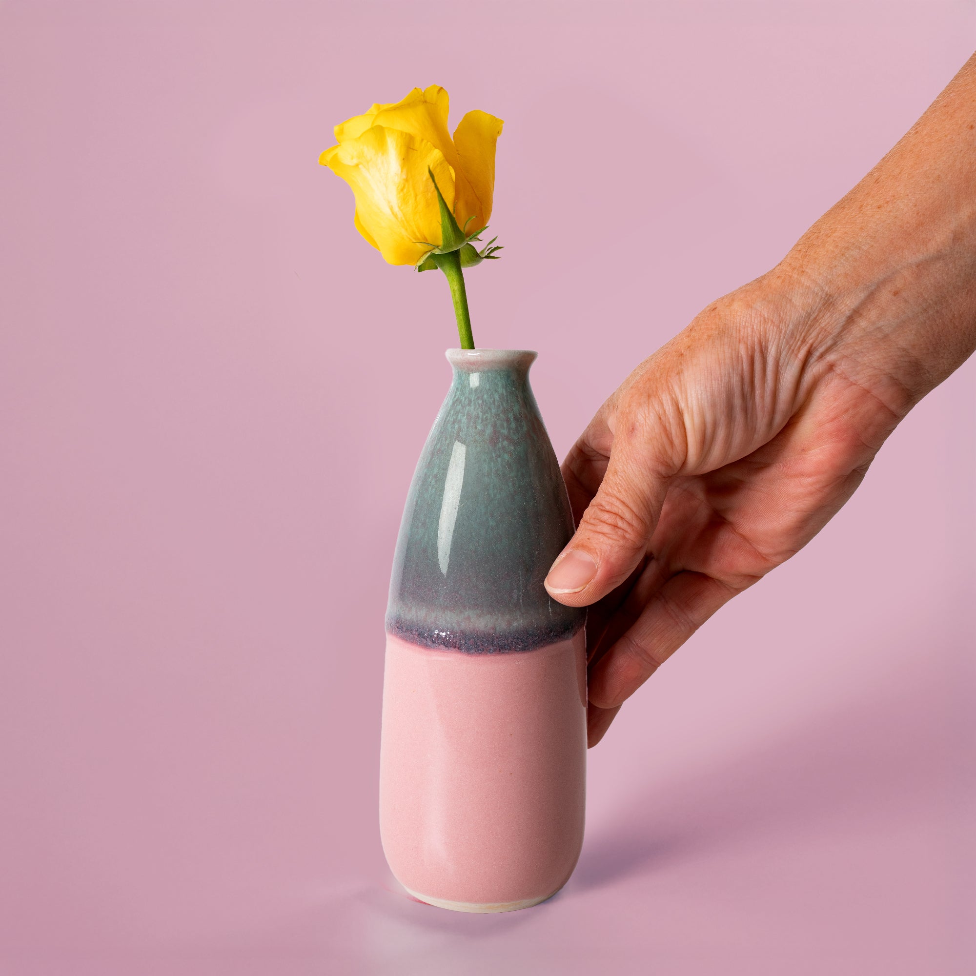 Pottery For The Planet artisan decorative vase for flowers in pink and green with a yellow rose