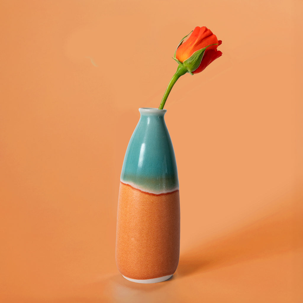 Pottery For The Planet artisan decorative vase for flowers in blue and orange holding a single red rose