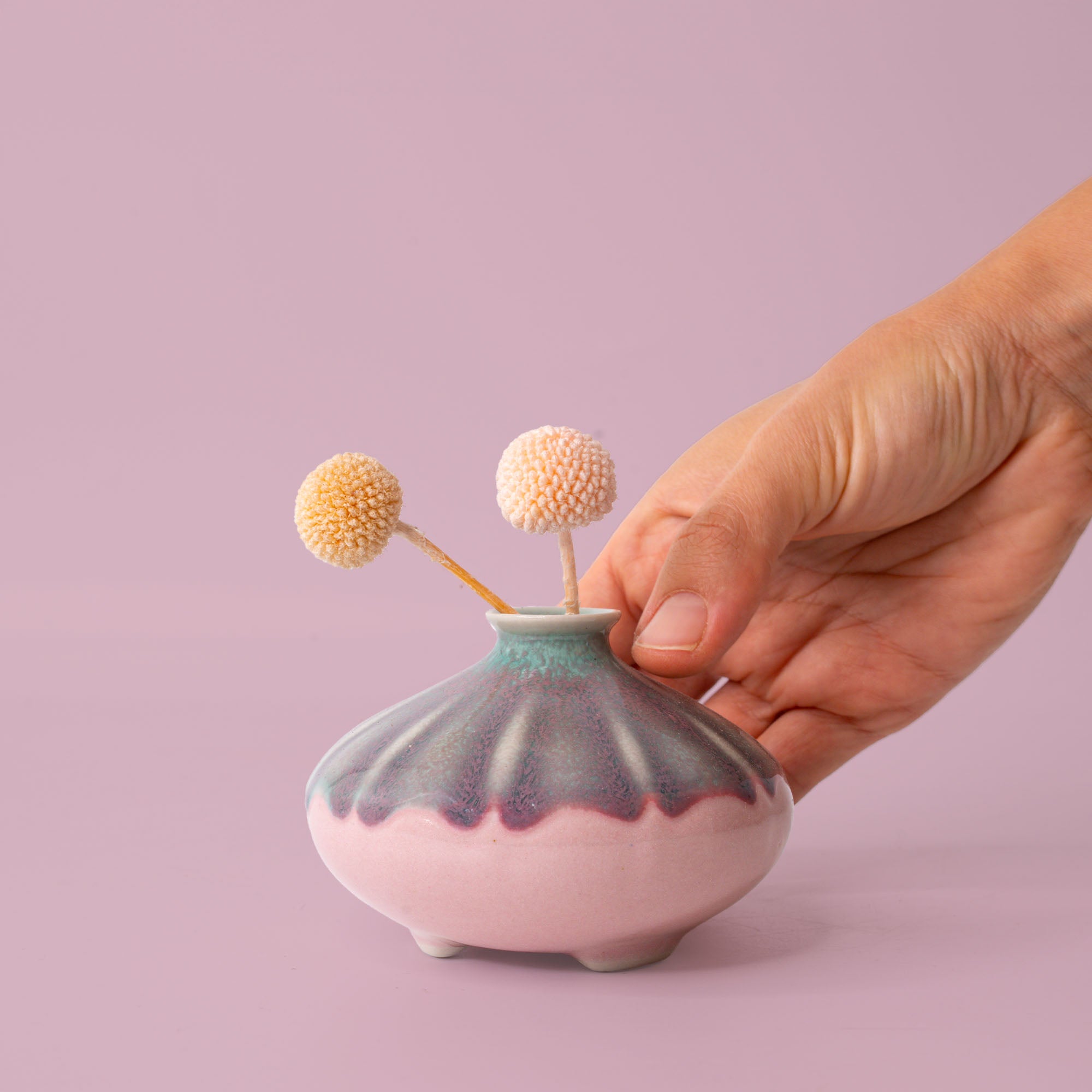 Small artisan decorative vases by Pottery For The Planet with unique pastel glaze held by hand