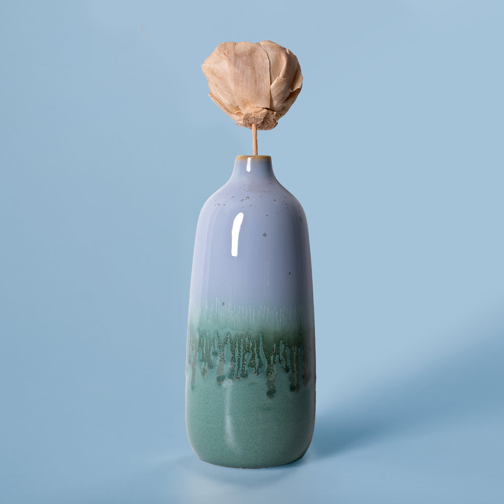 Pottery For The Planet eco-friendly home decor vase with green and blue glaze and a dried flower