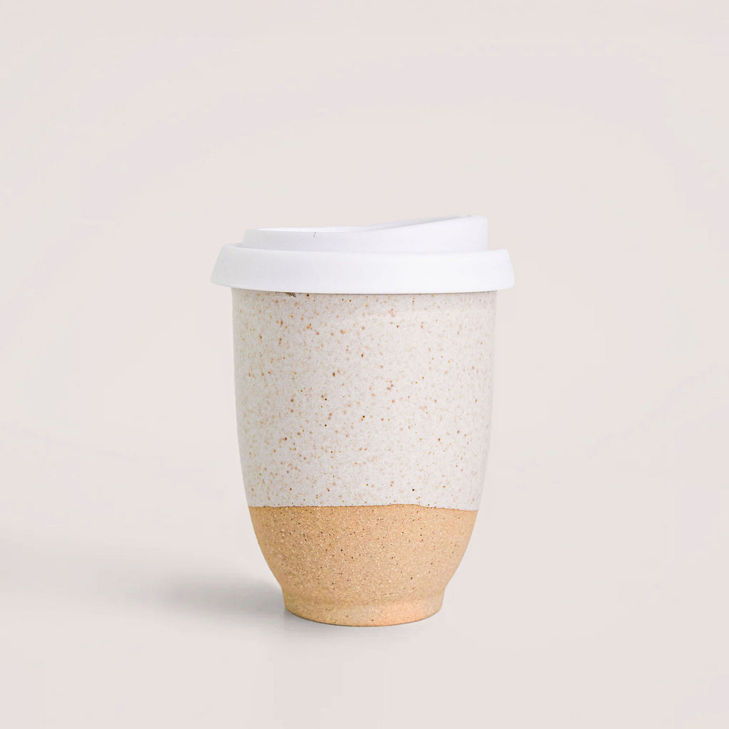Handmade reusable coffee cup by Pottery For The Planet with speckled white top and natural clay bottom