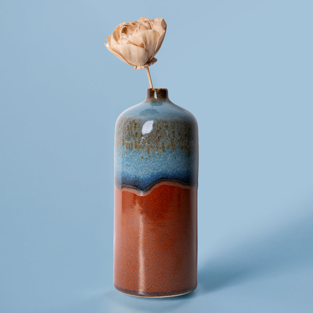 Pottery For The Planet medium decorative bud vase in blue and rust colors with single dried flower