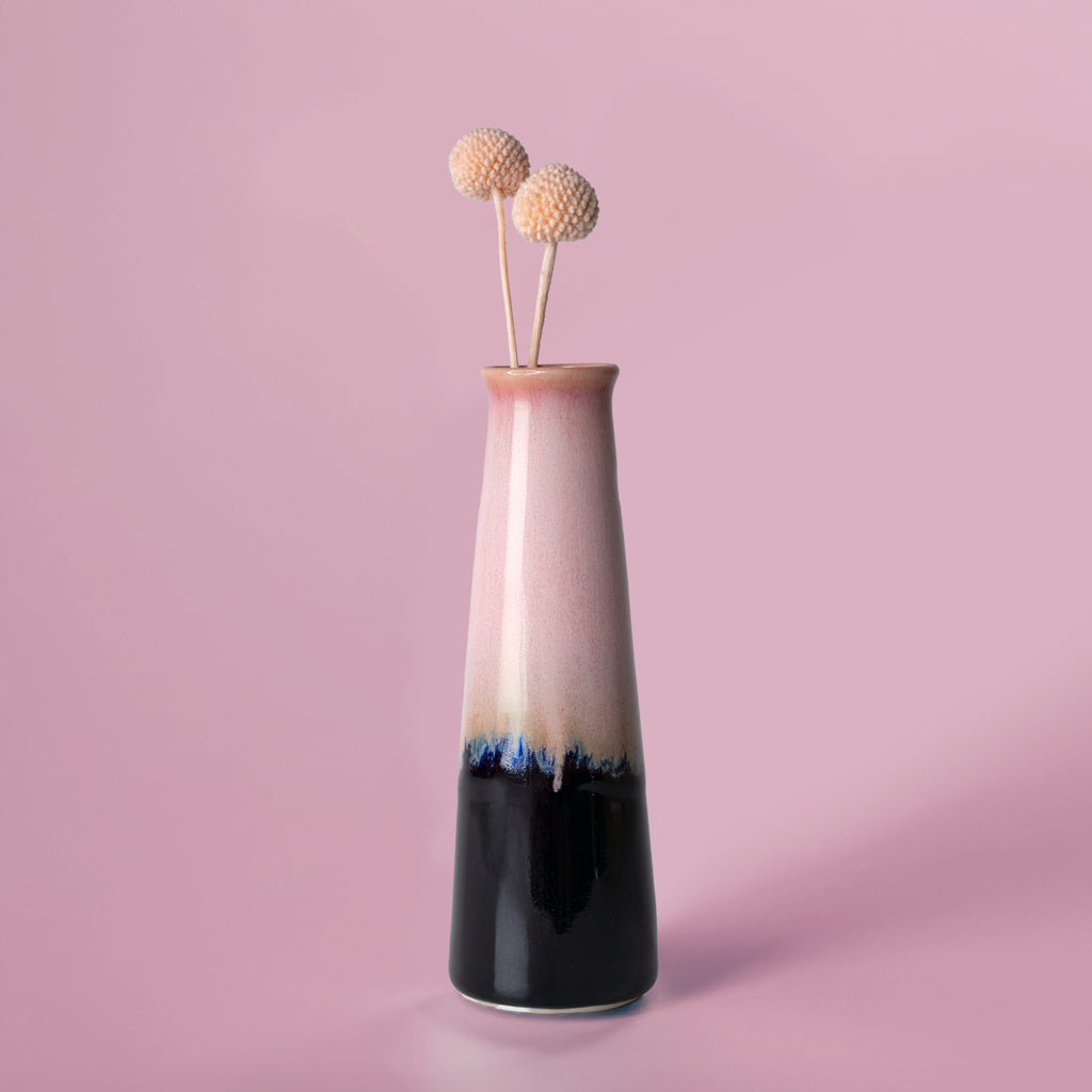 Pottery For The Planet tall two-tone sustainable home decor vase with dried flowers on pink background