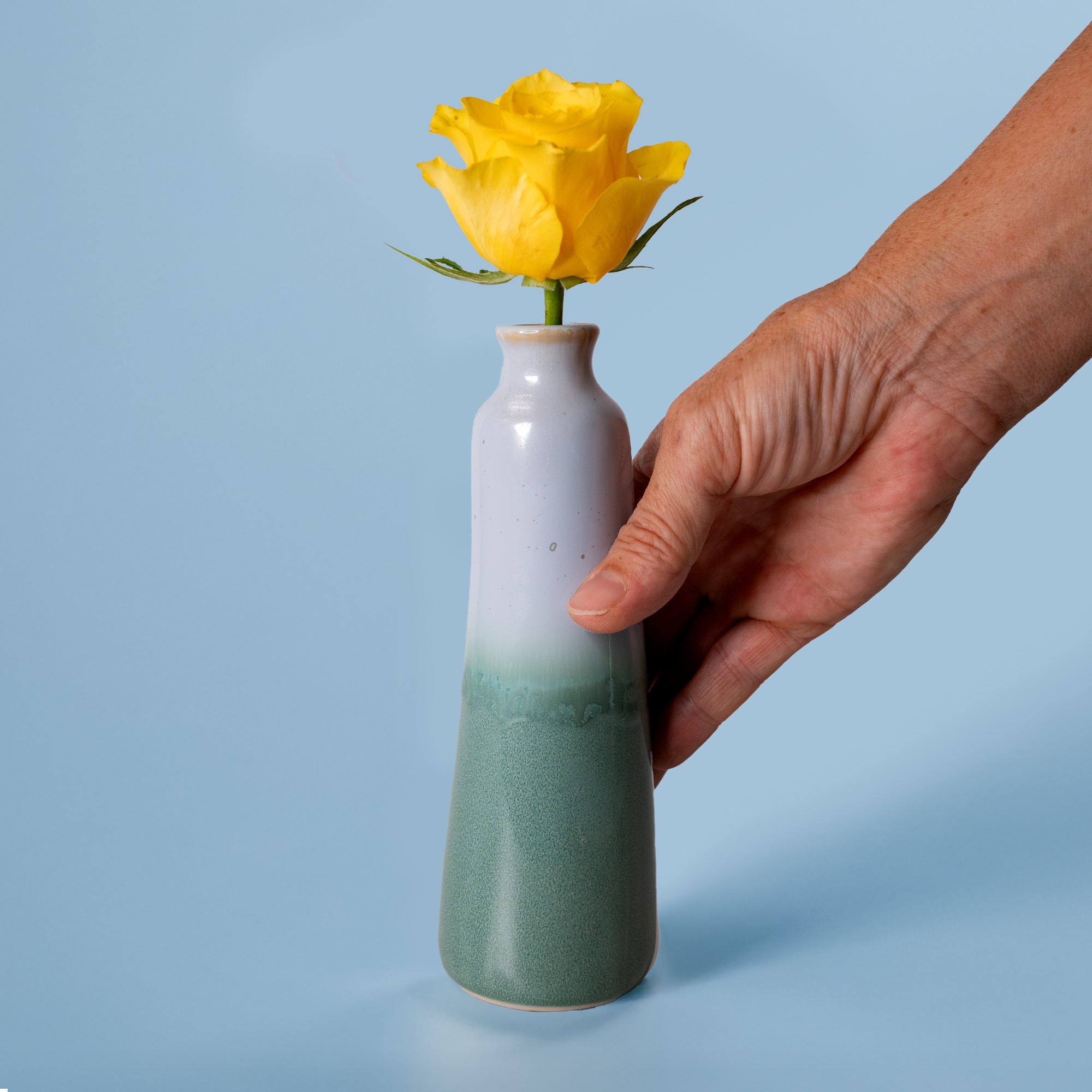 Pottery For The Planet unique handmade ceramic vase with green and white glaze holding a yellow rose