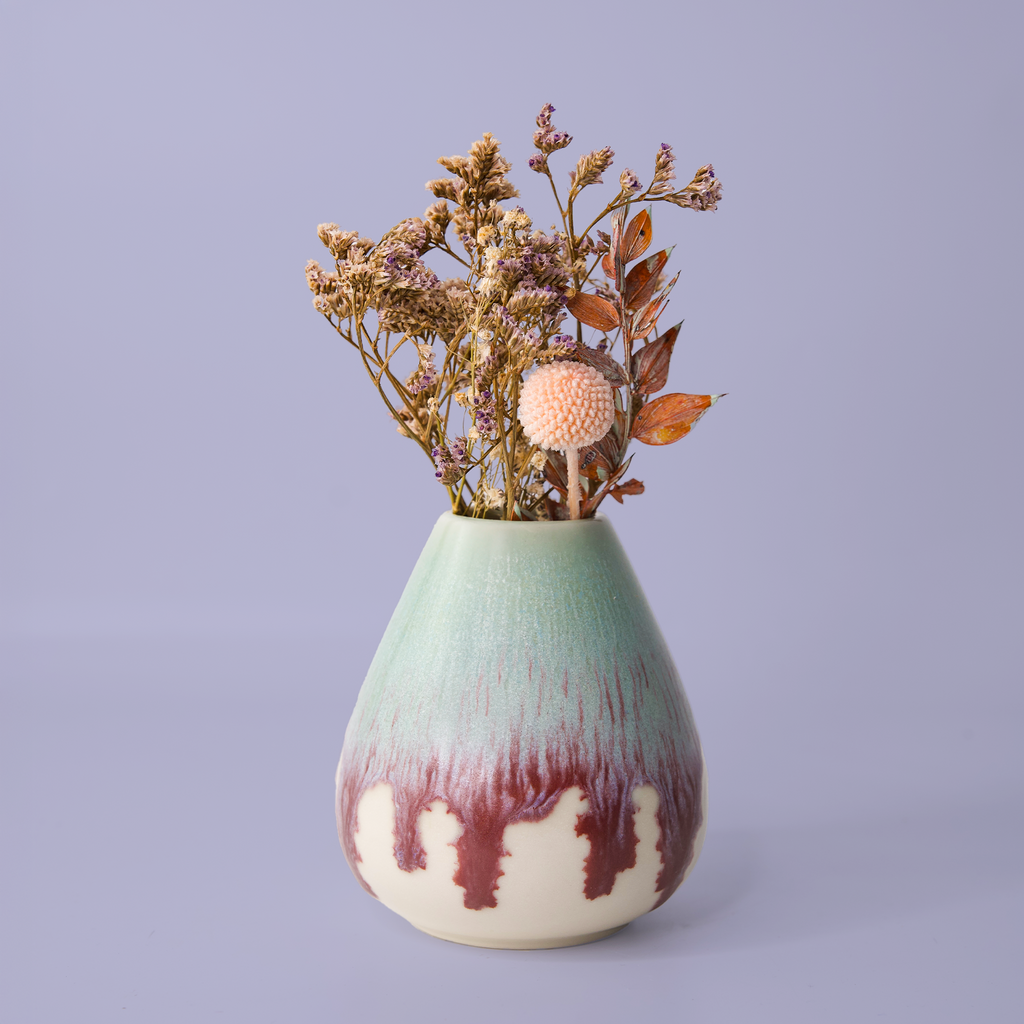 Unique pottery flower vase by Pottery For The Planet with green and brown glaze holding dried flowers