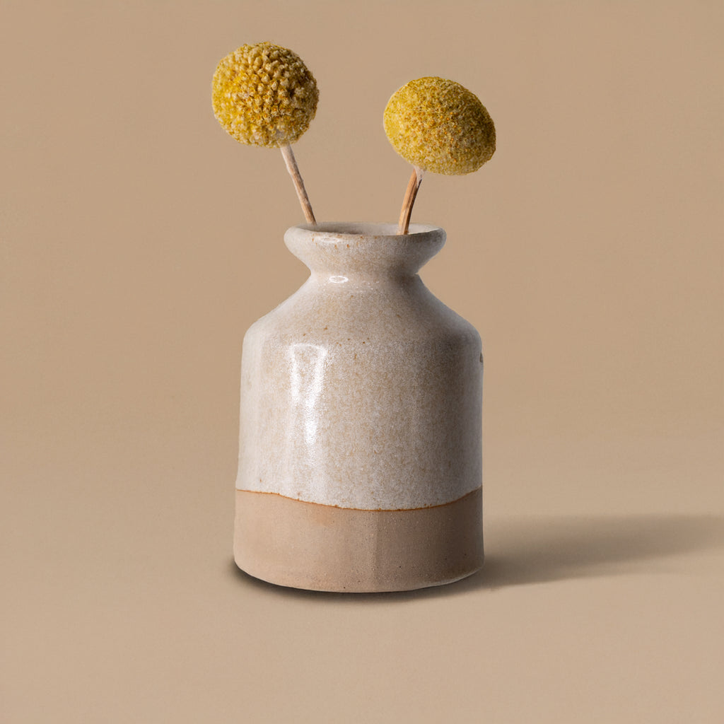 Pottery For The Planet miniature decorative vase for shelf with beige and off-white glaze holding yellow billy balls