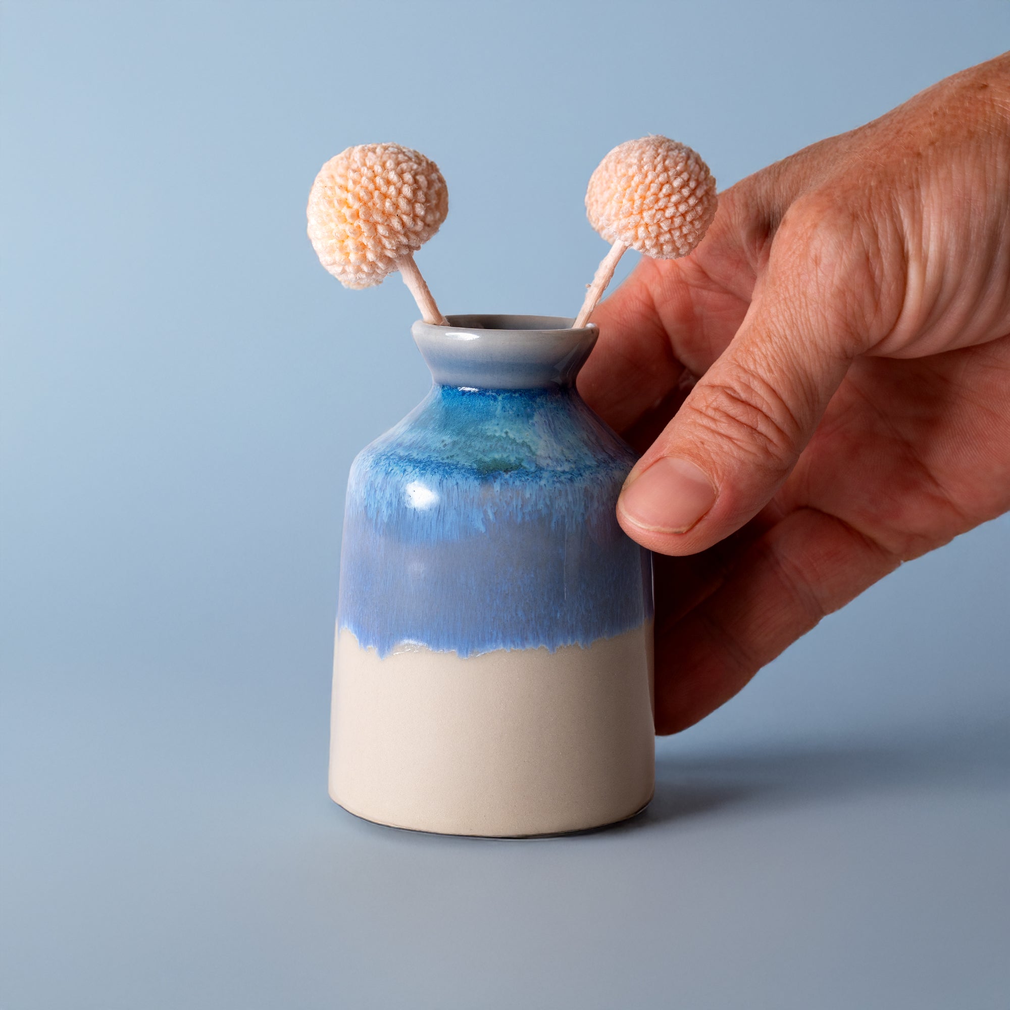 Pottery For The Planet miniature decorative vase for shelf in blue and white ceramic held by hand