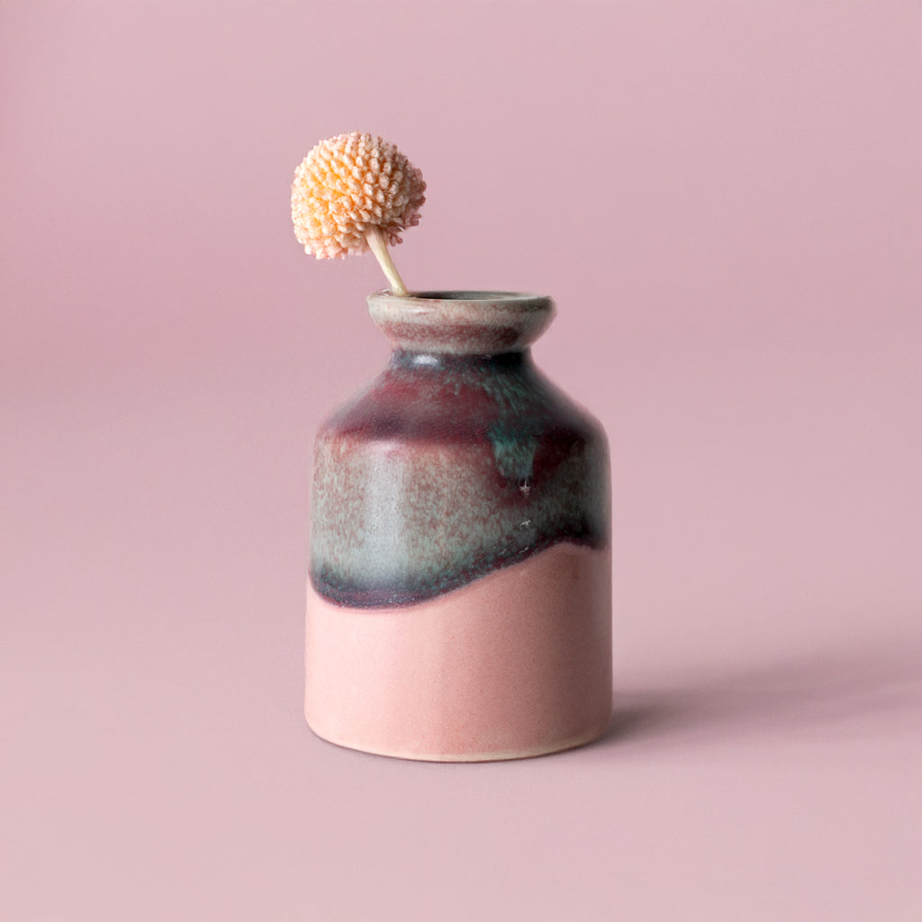 Pottery For The Planet miniature decorative vase for shelf with pink and dark glaze holding a small flower