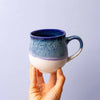 blue and white ceramic mug in hand medium