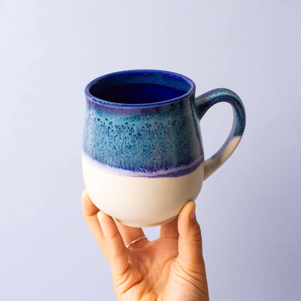 blue and white ceramic mug in hand large