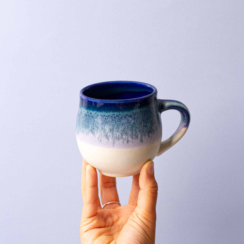 blue and white ceramic mug in hand small